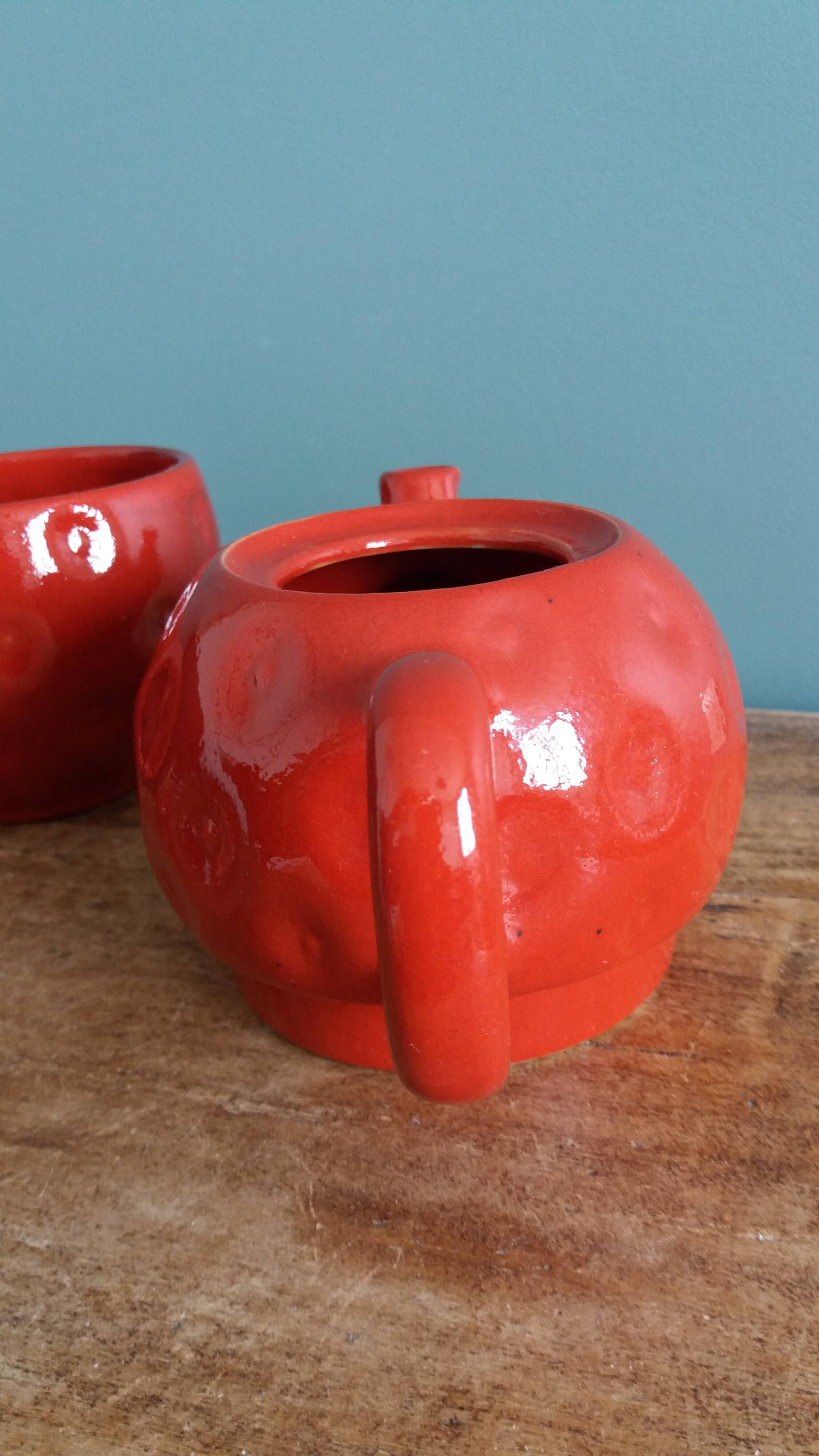 Teapot and cup in the shape of a strawberry.