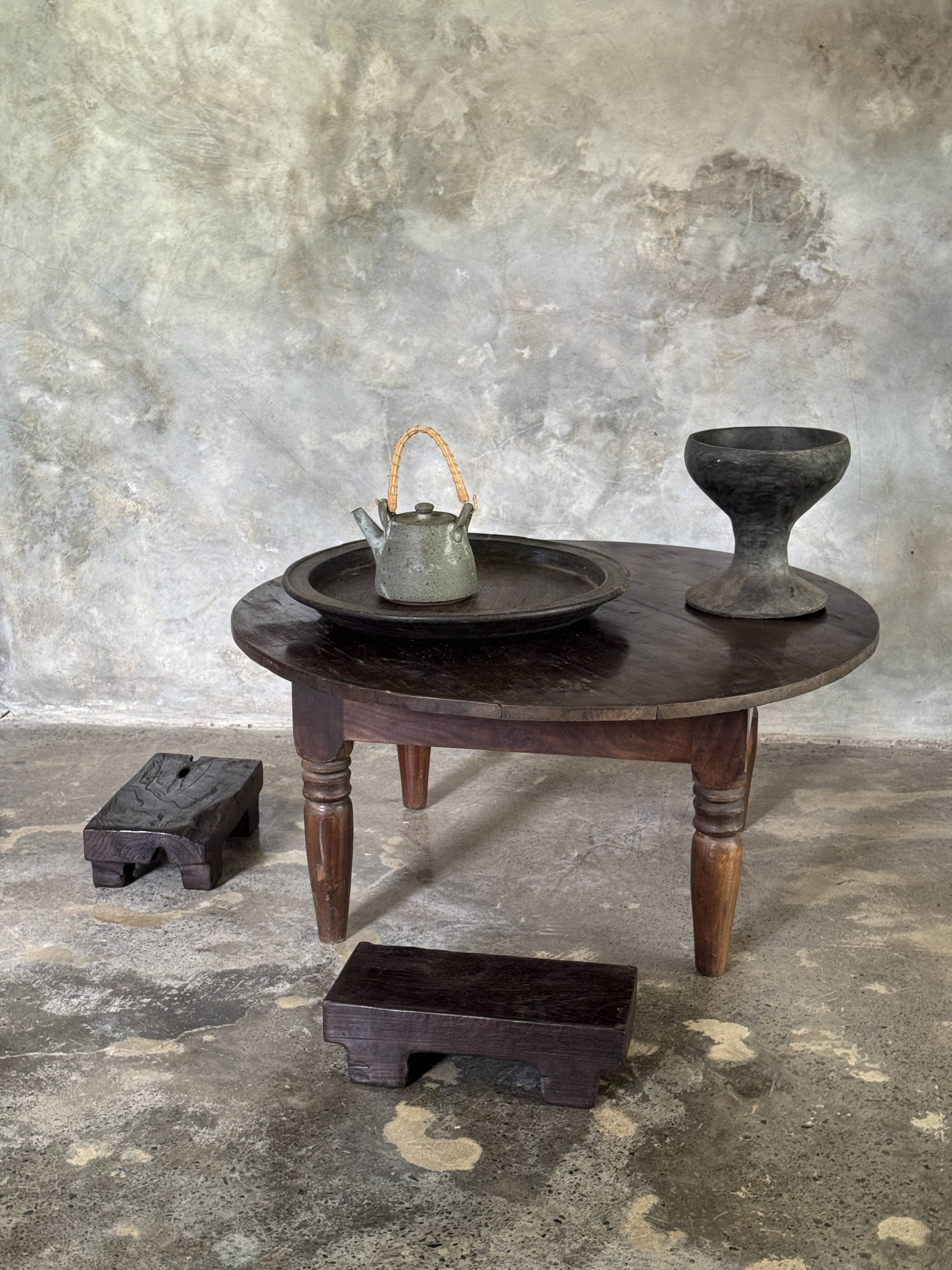 Coffee table, round antique Indonesian teak table with straight legs.