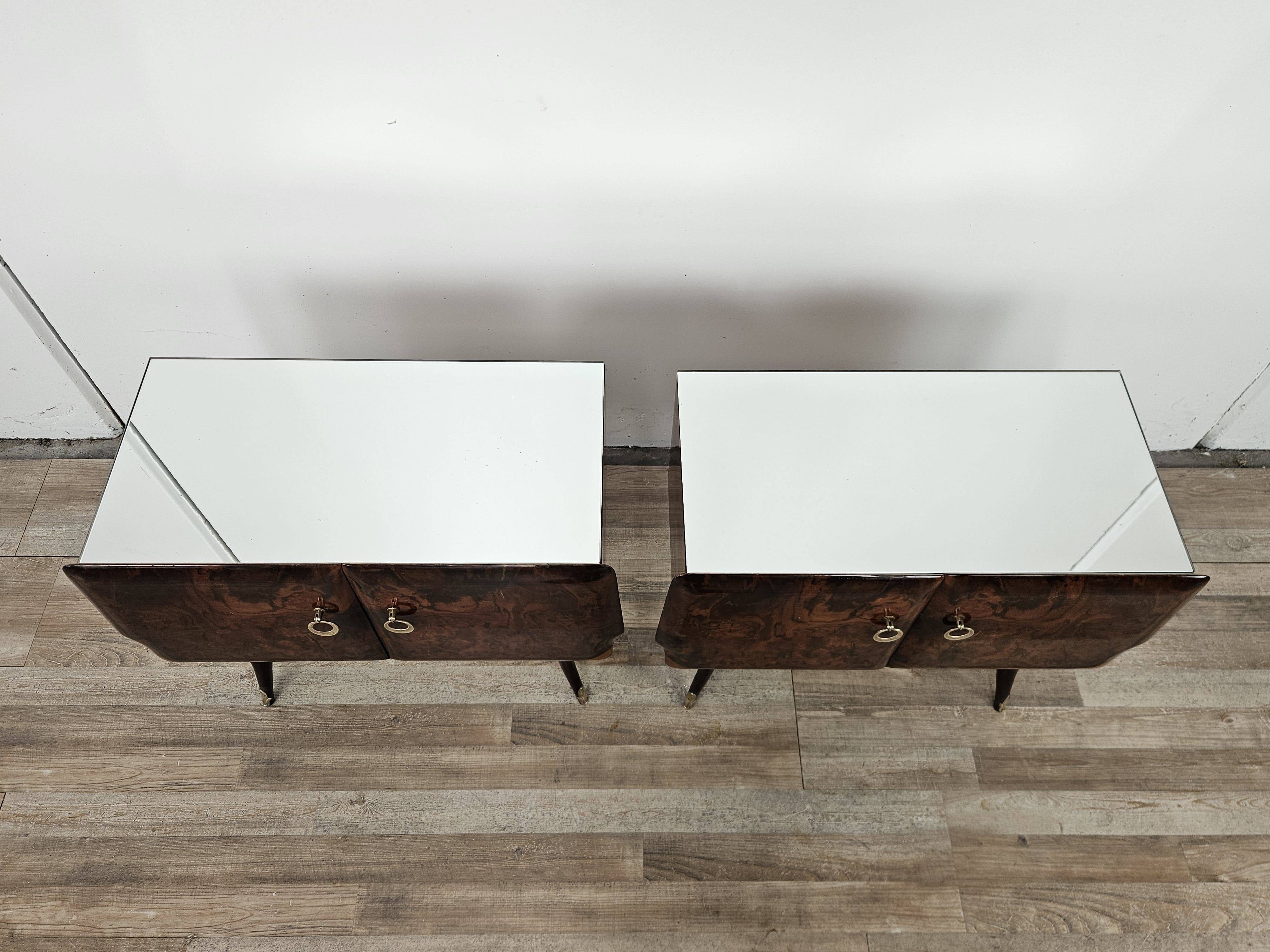 Mid-century mahogany bedside tables with mirrored tops.