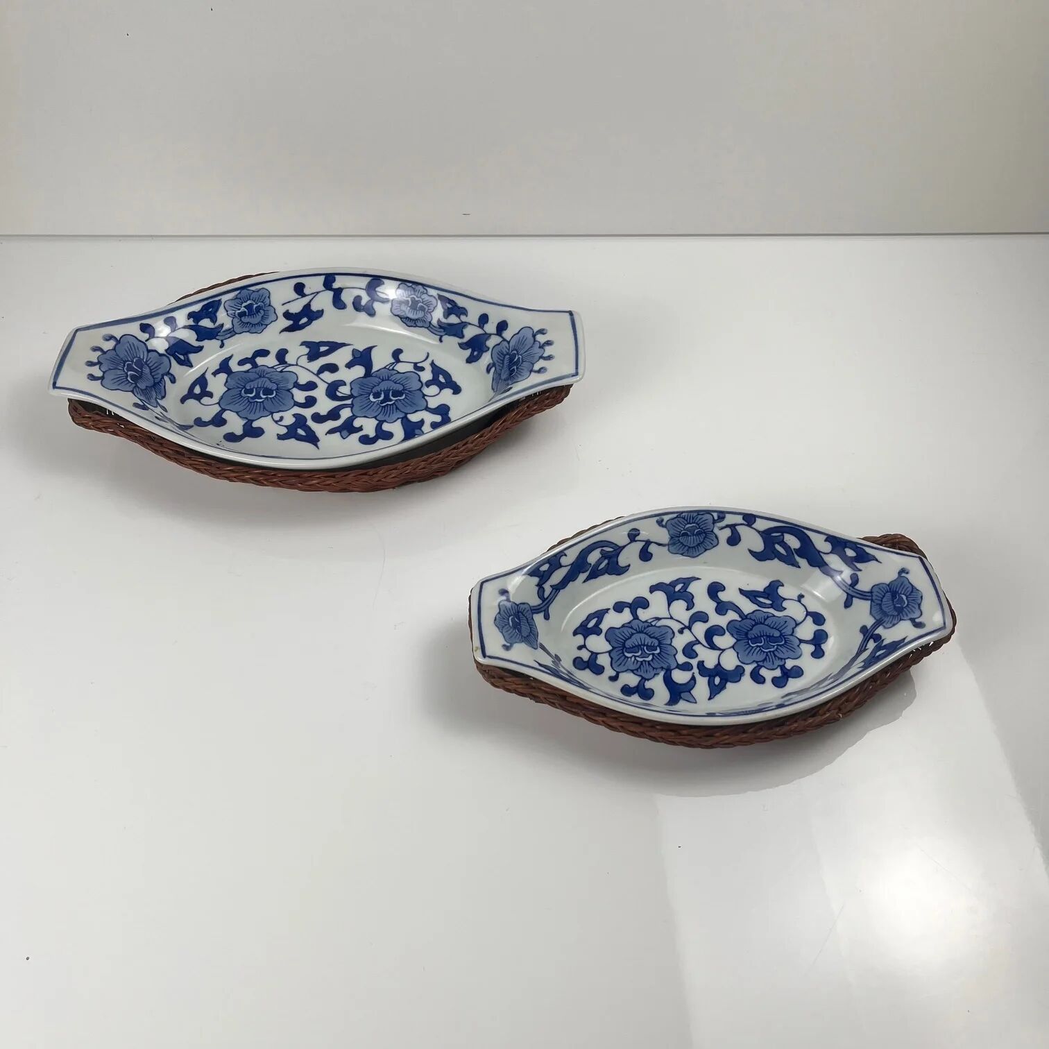 Set of 6 ceramic presentation plates in white and blue, floral pattern with woven wicker frame, 1970s/80s.