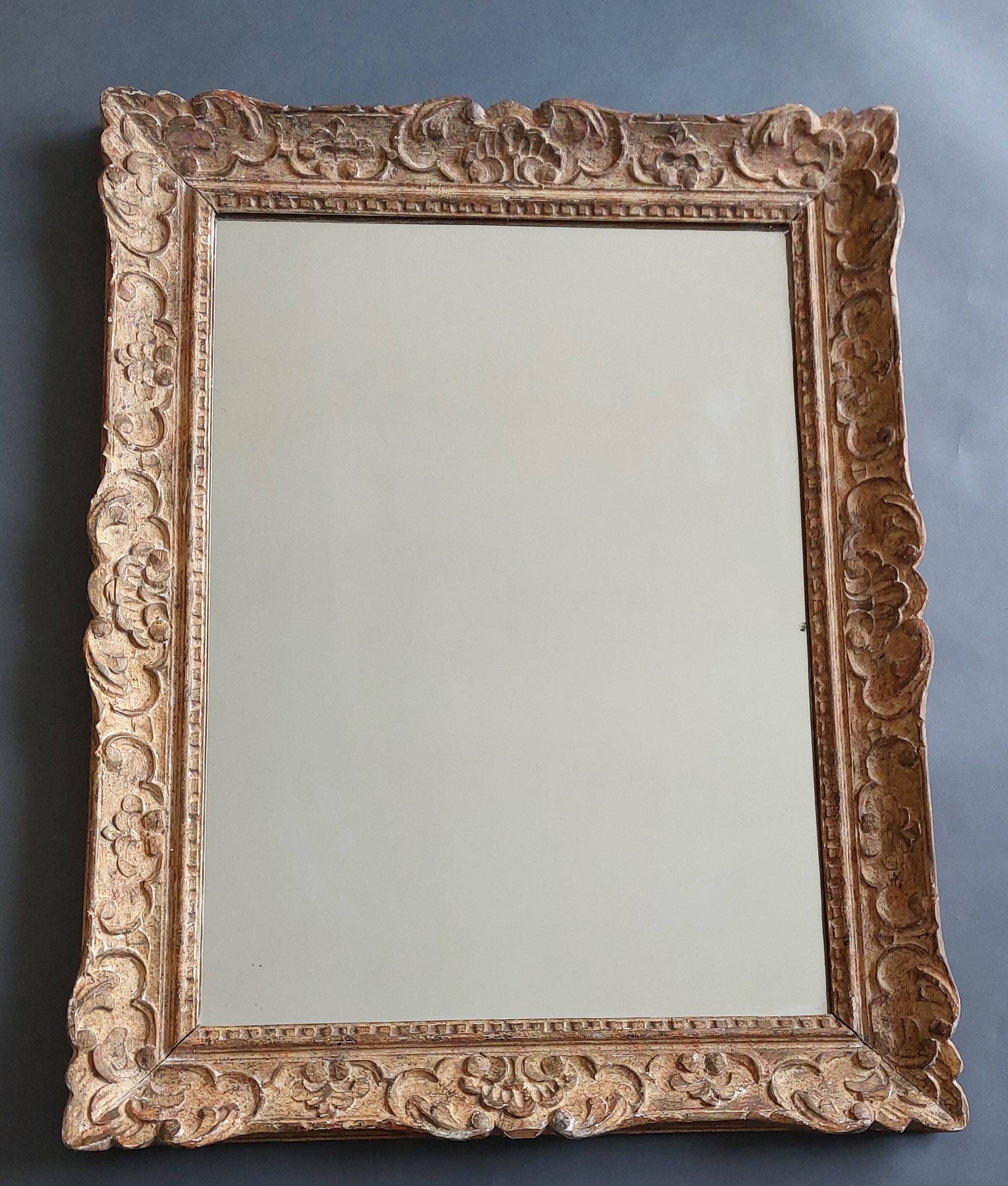 Large Montparnasse rocaille style frame in carved wood mounted in mirror.
