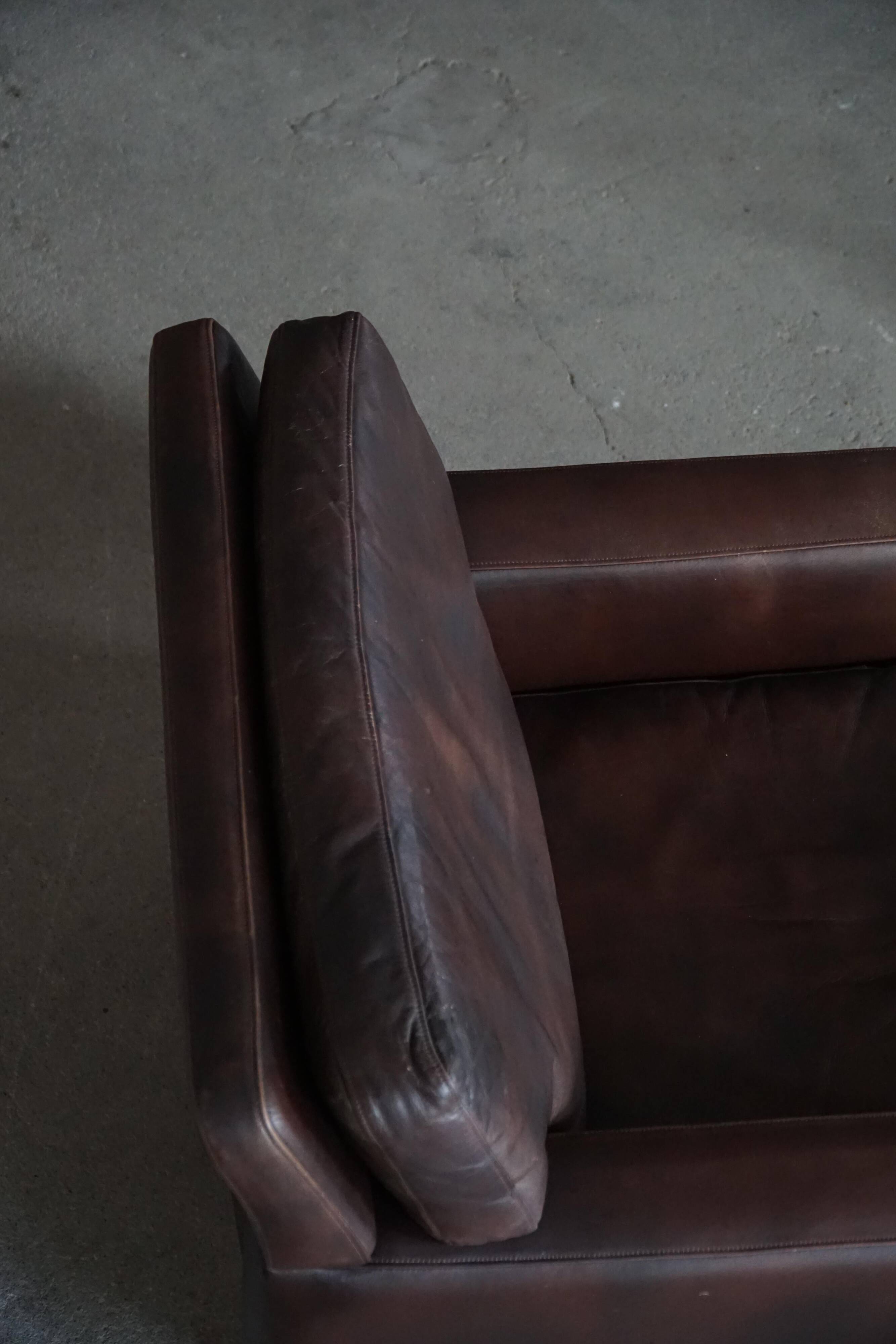 Pair of modern Danish lounge chairs in dark brown leather and rosewood, 1960s.