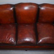 Restored Victorian sofa in leather with claw feet and feather cushions.