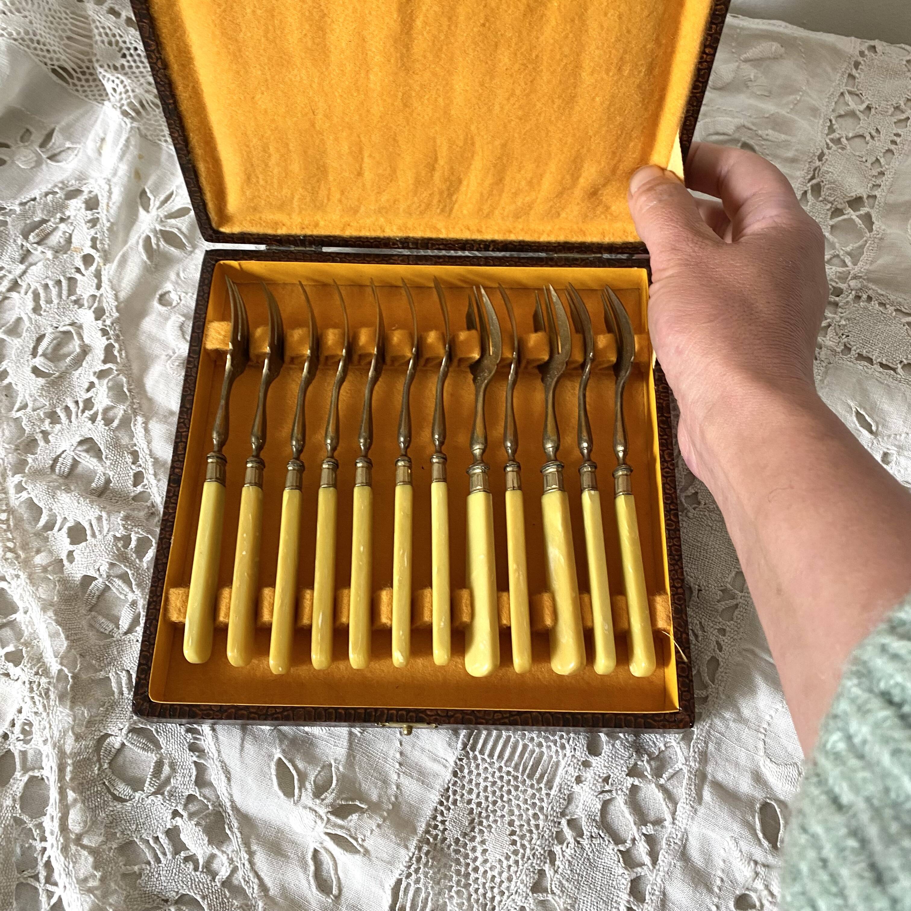 Antique dessert forks in brass and bakelite