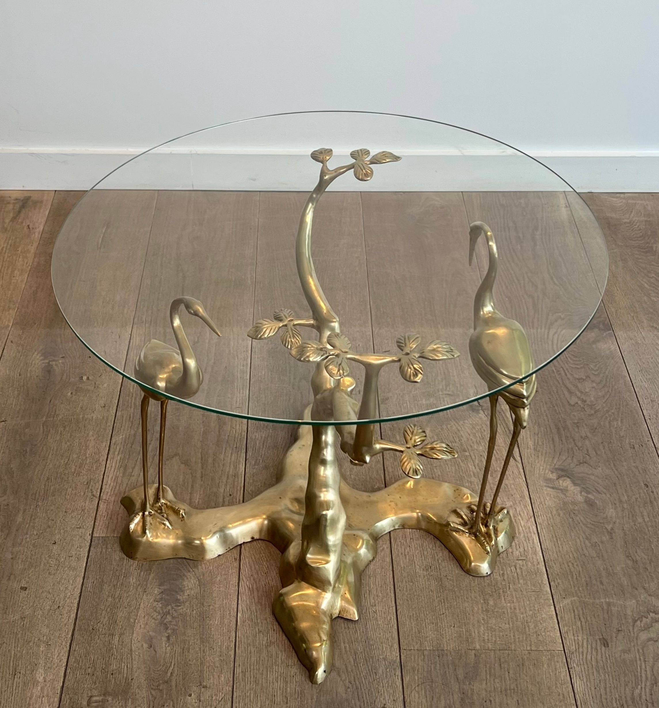 Coffee table model with cranes surrounding a brass bonsai and round glass top by Willy Daro.
