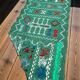 Handwoven green Moroccan hallway rug with geometric patterns.