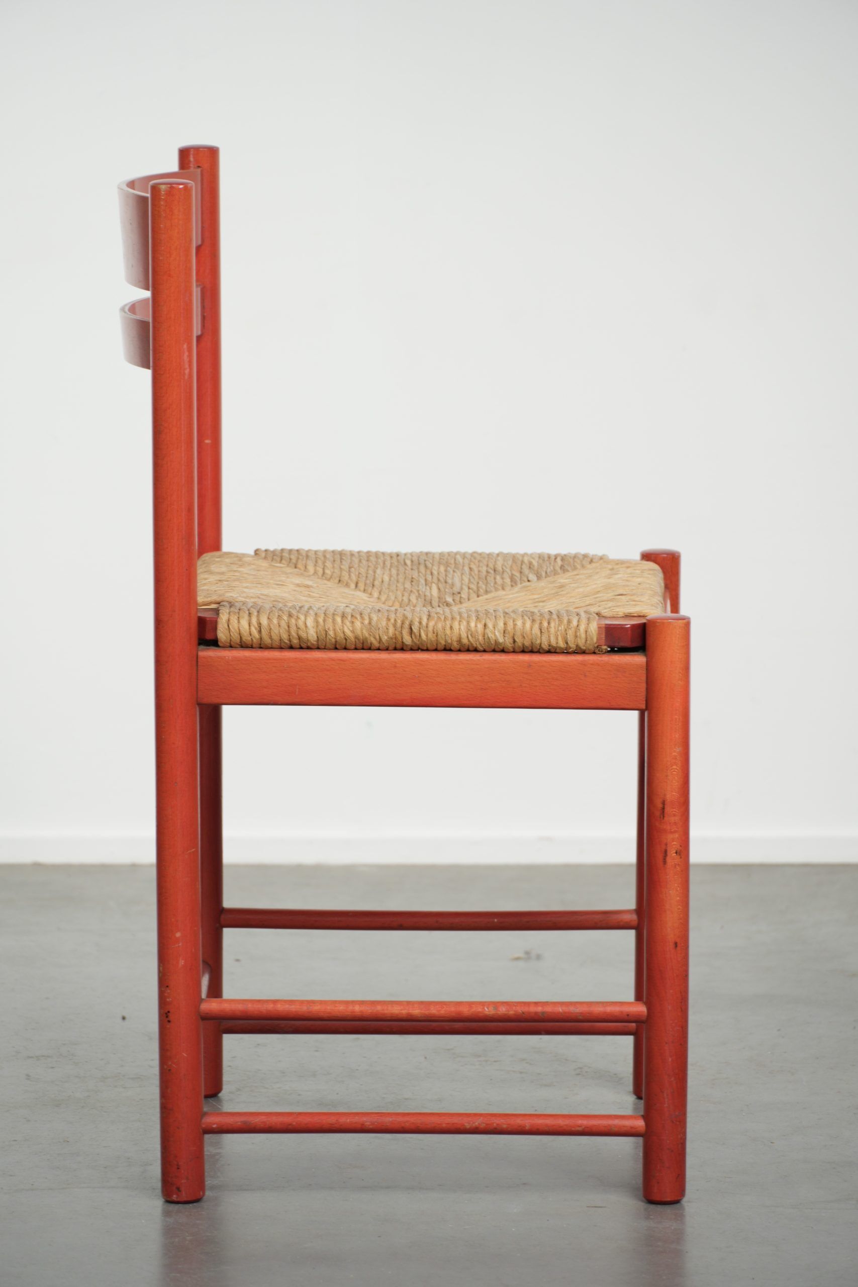 Nice red vintage wooden chair from the 1970s with a woven wicker seat