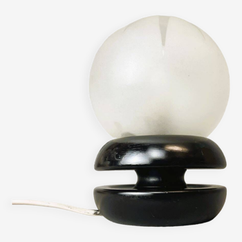 Small black wooden table lamp with frosted glass globe