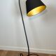Design floor lamp in black lacquered metal and brass.