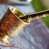 Mortar and its brass pestle with oriental gold and silver motifs