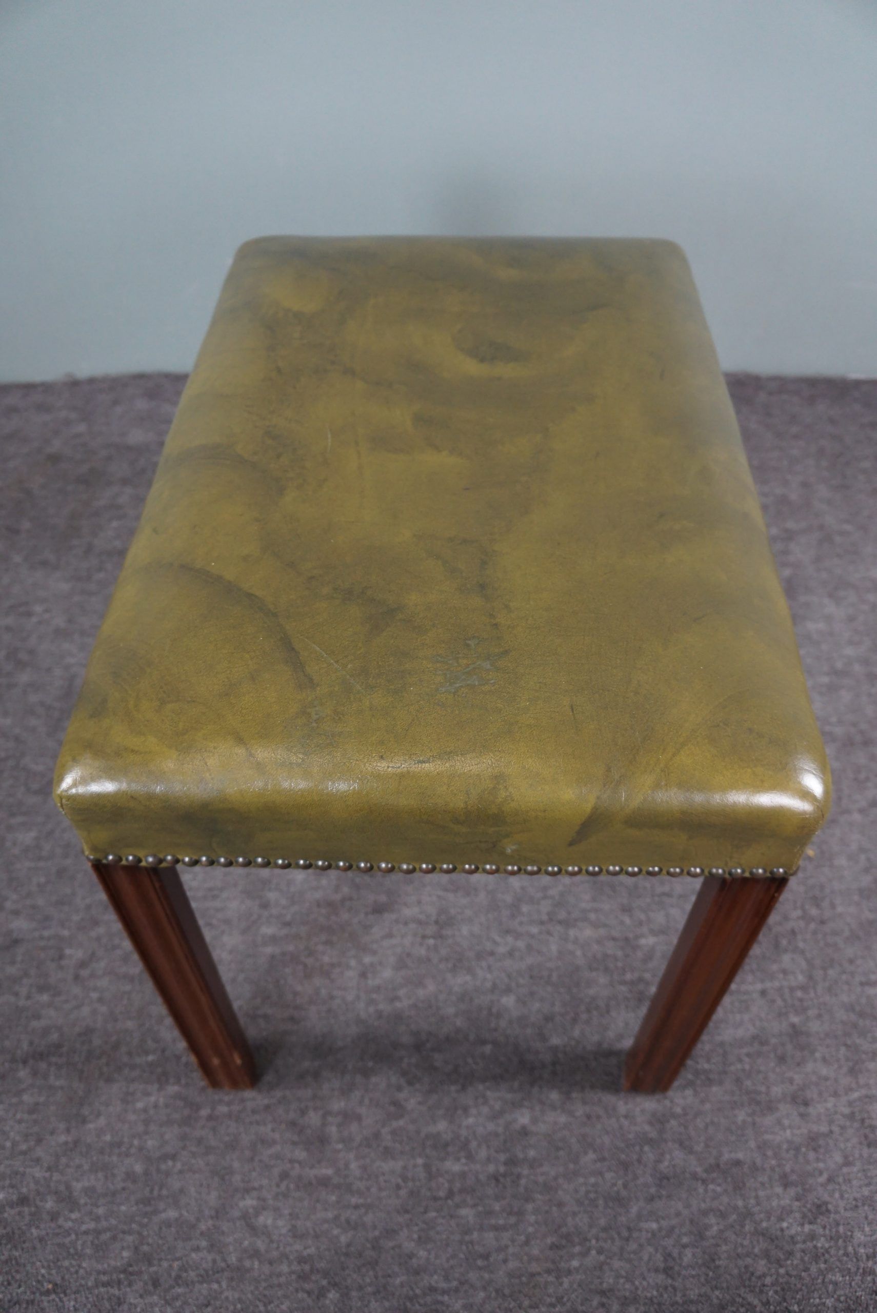 Elegant armchair and footrest in English green leather
