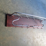Chrome metal patere in a wooden support panel coat veneer.
