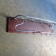 Chrome metal patere in a wooden support panel coat veneer.