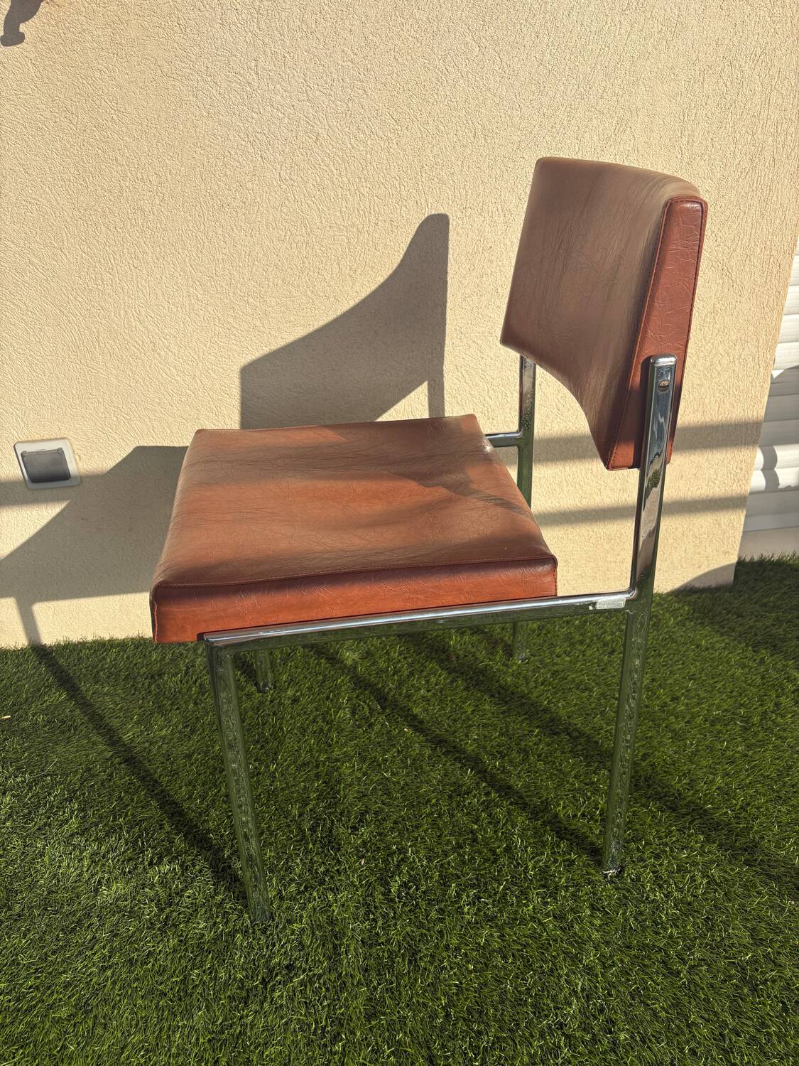 A pair of vintage brown Skaï chairs.