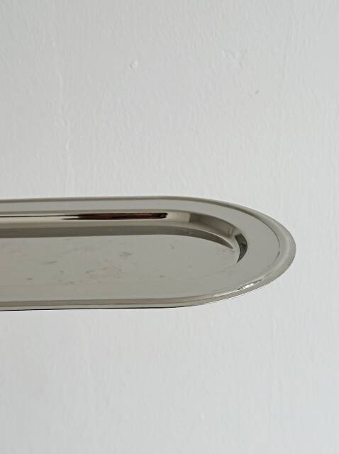 Small antique tray made of lightweight metal.