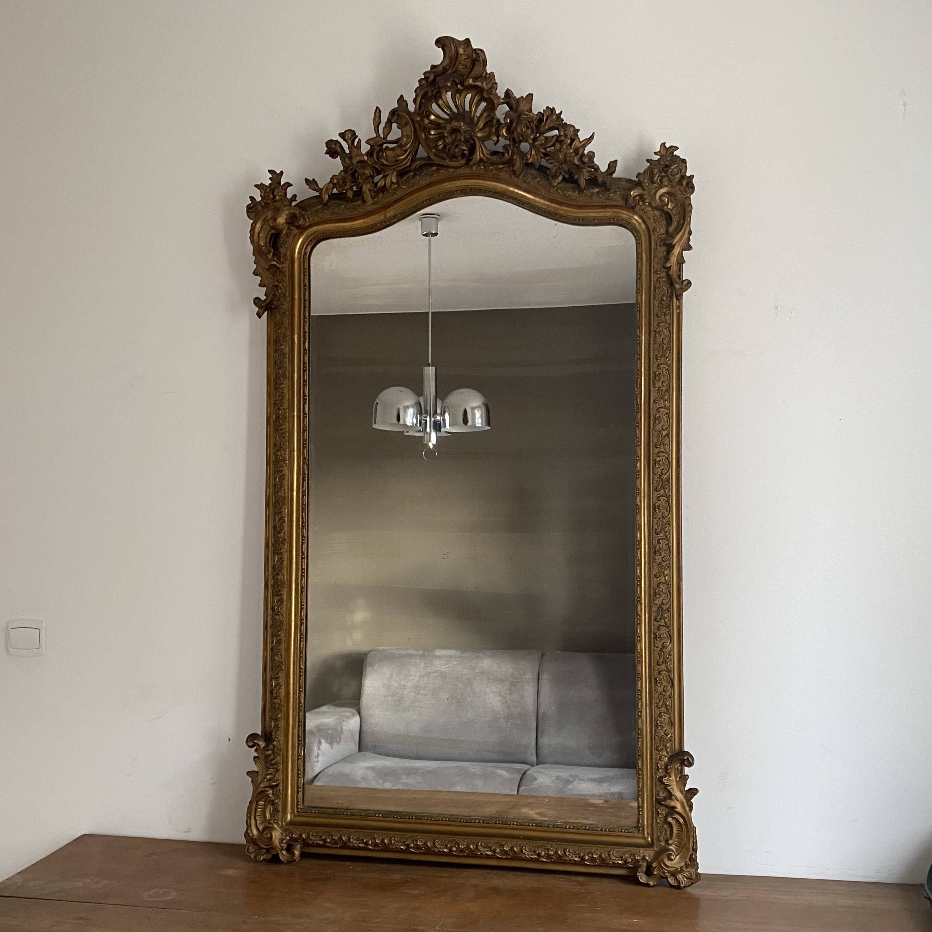 Late 19th century gilded mirror with decorated pediment. 155x88.