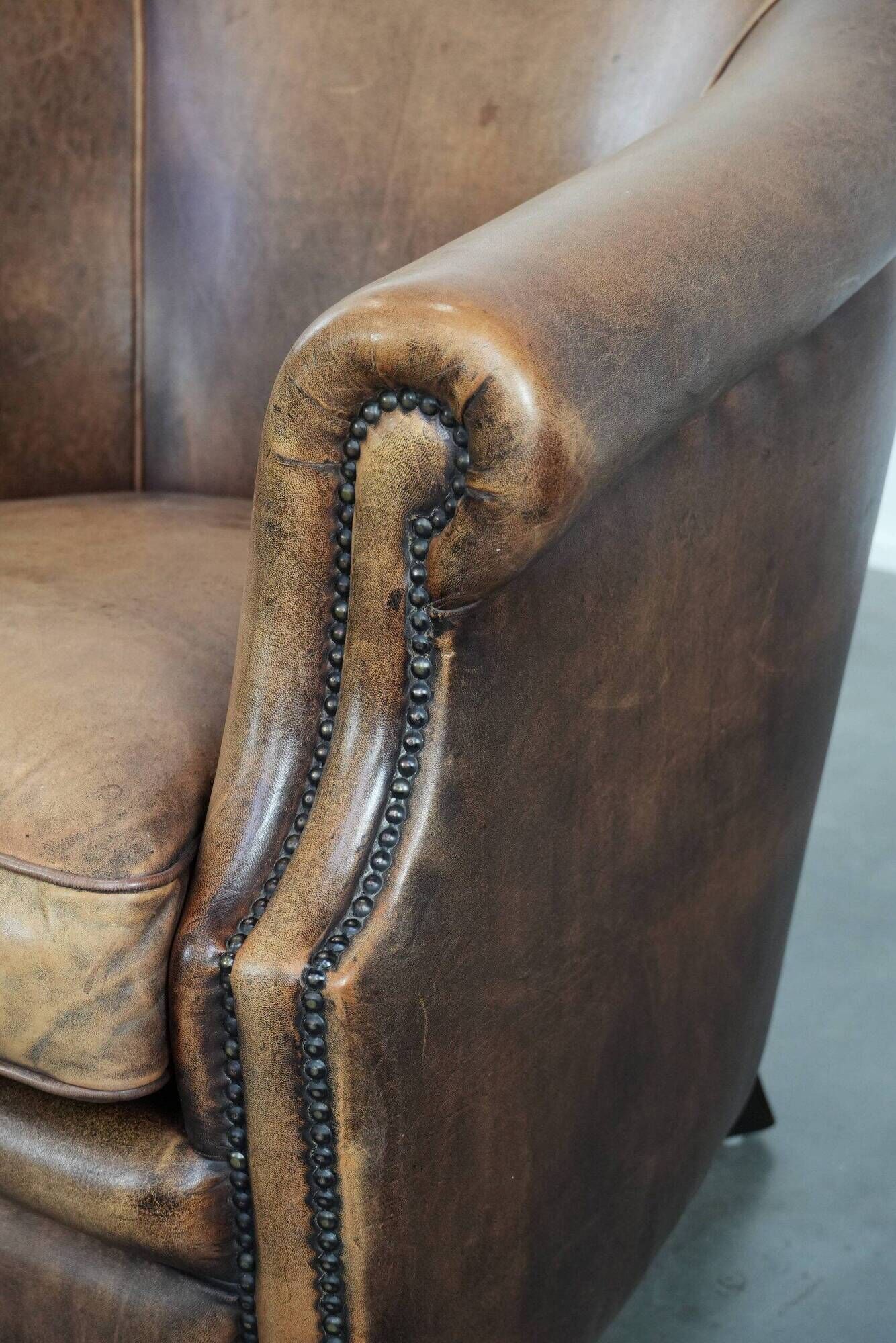 Club chair made of sheepskin leather finished with decorative nails