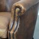 Club chair made of sheepskin leather finished with decorative nails