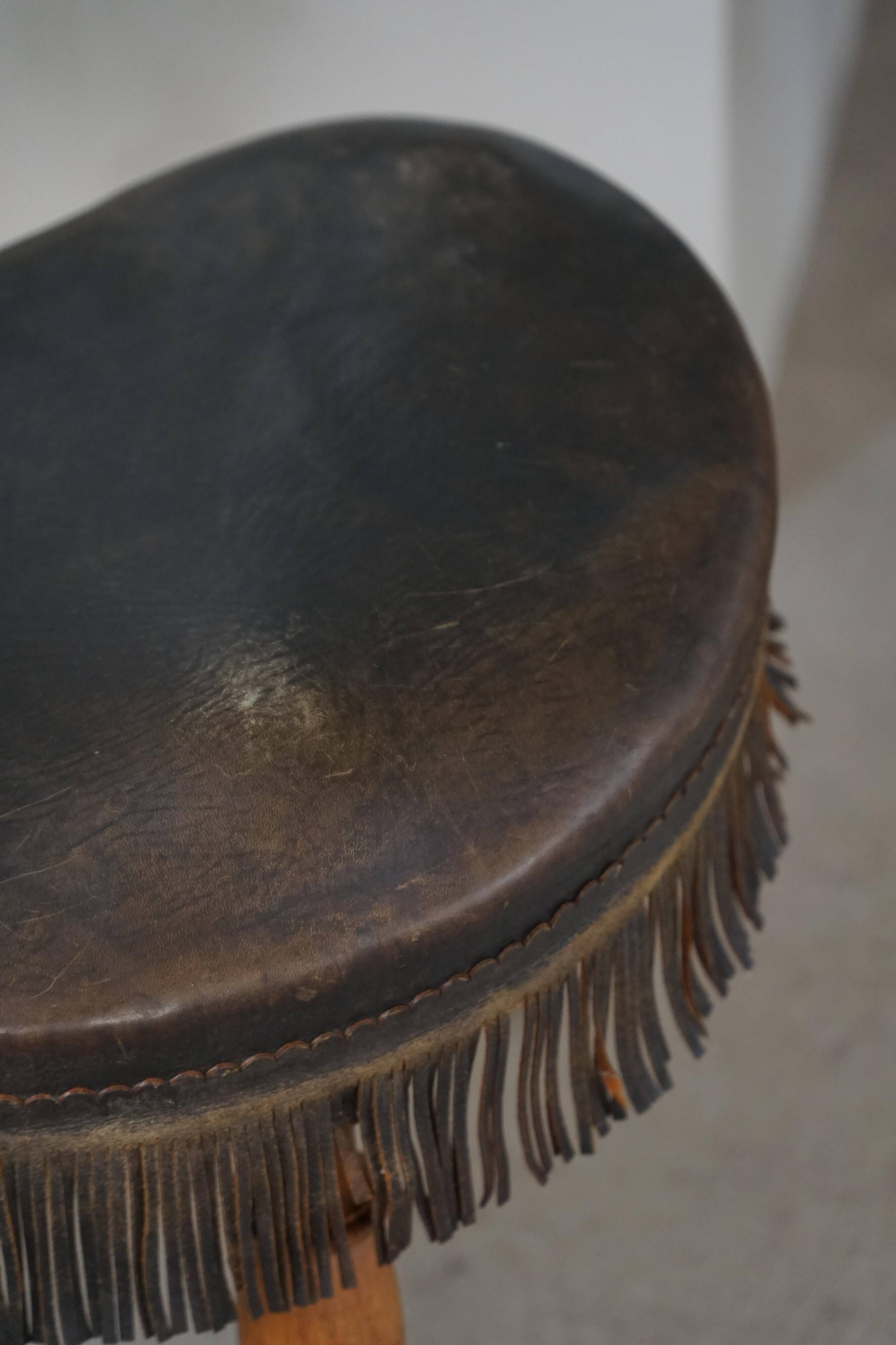 Danish oak tripod stool from the early 20th century with leather fringe, 1930s.
