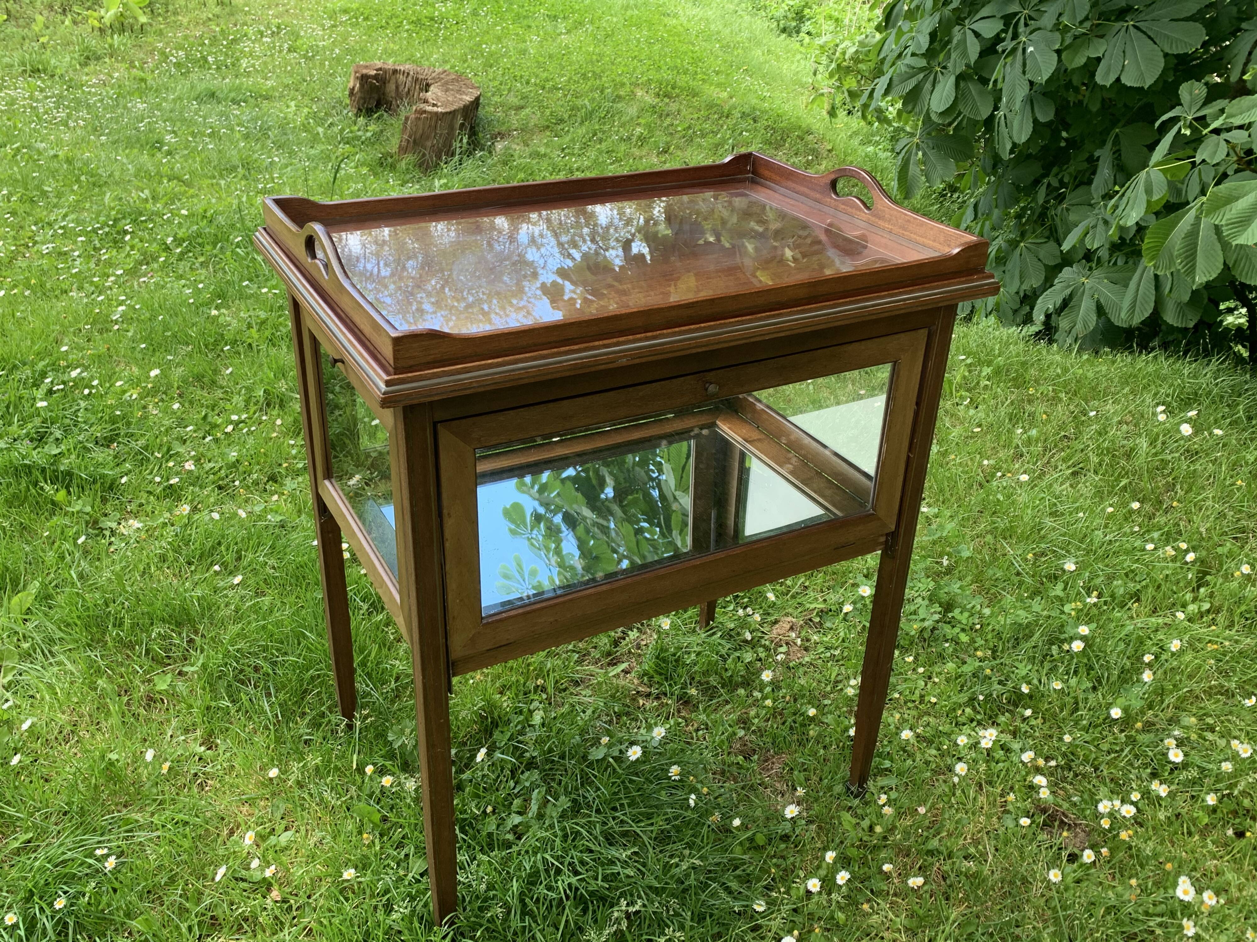 Glass-enclosed old tea table with wooden tray, bronze and brass