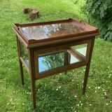 Glass-enclosed old tea table with wooden tray, bronze and brass