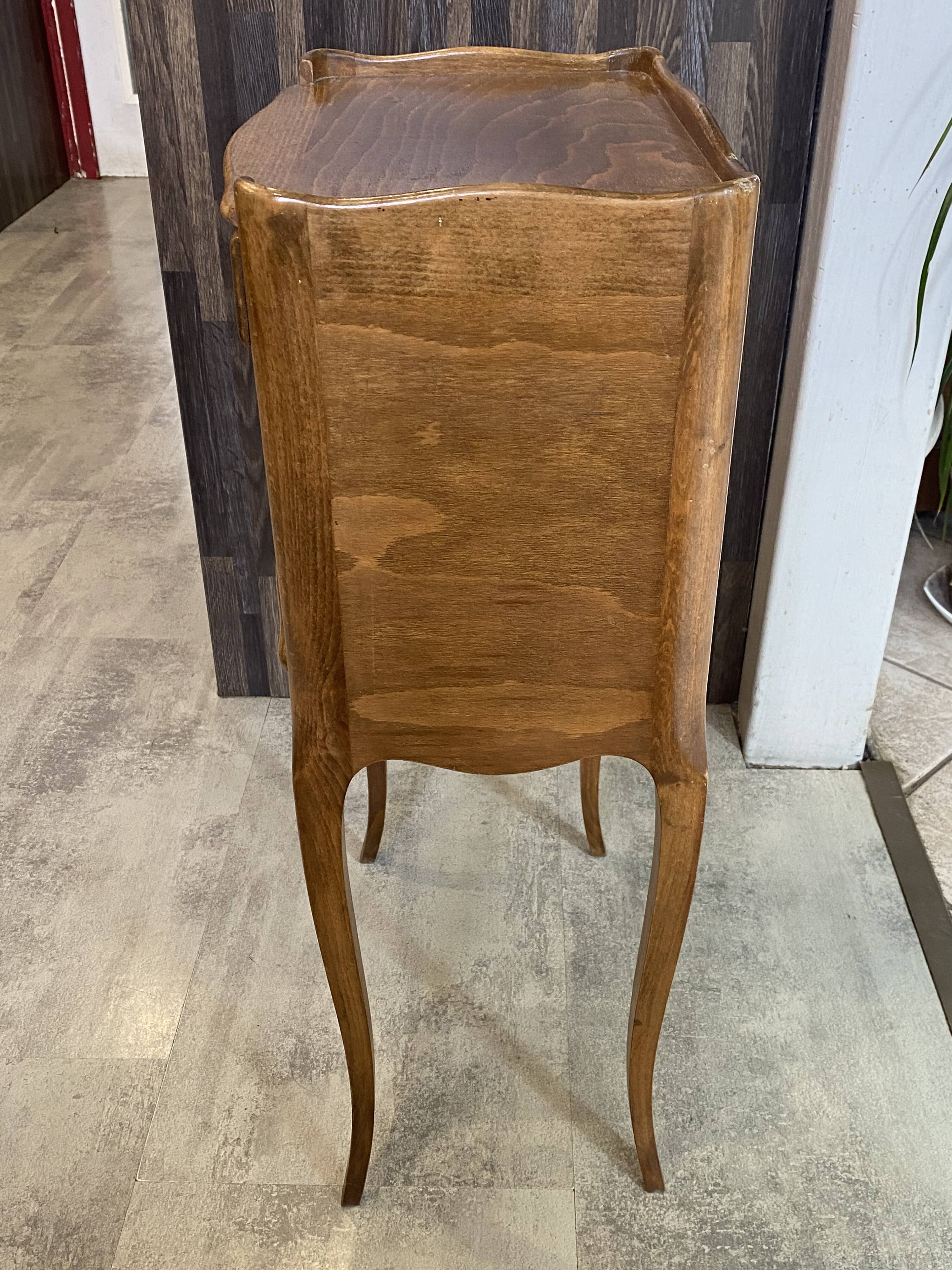 A bedside table with a drawer and a niche in Louis XV style.