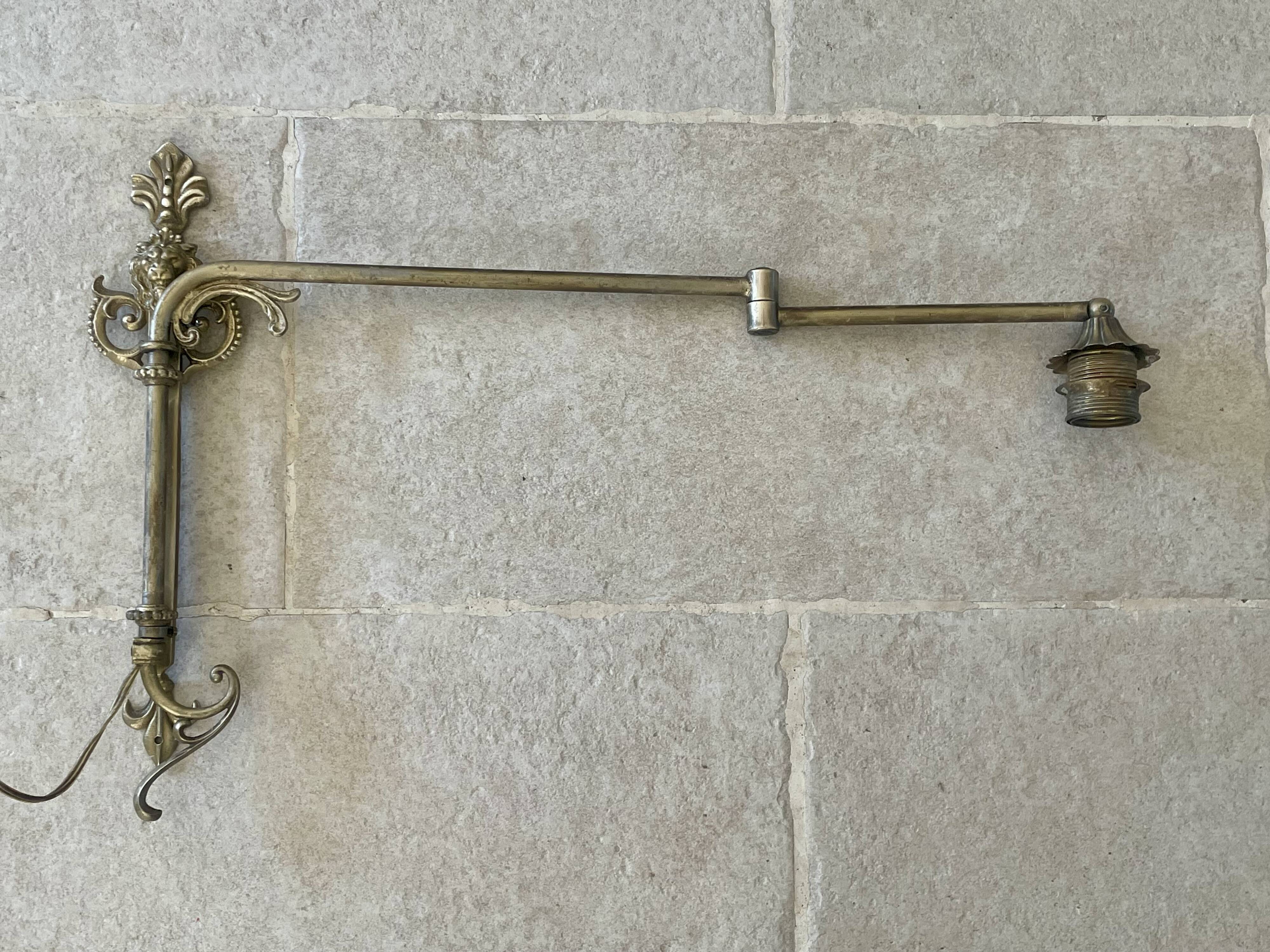 Adjustable wall light in brass and gold metal.