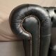 Two seater black leather chesterfield sofa