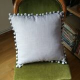 Gray cushion with pompoms