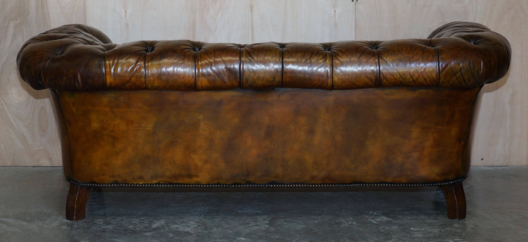 Victorian Chesterfield leather upholstered canapé with feather cushions.