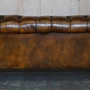 Victorian Chesterfield leather upholstered canapé with feather cushions.
