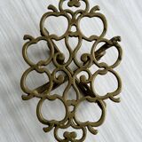 Brass trivet with openwork pattern in the shape of apples.