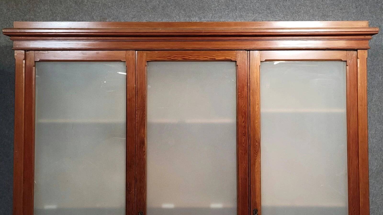 Large pine bookcase with three doors, fitted with frosted glass.