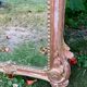 Mirror above a wooden and gilded stucco fireplace in the style of the 18th century.