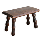 Vintage rectangular stool in dark wood with turned legs.