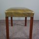 Elegant armchair and footrest in English green leather