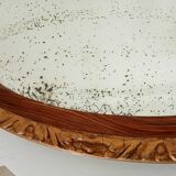 Antique oval mirror with beveled glass in wood and stucco, 19th century