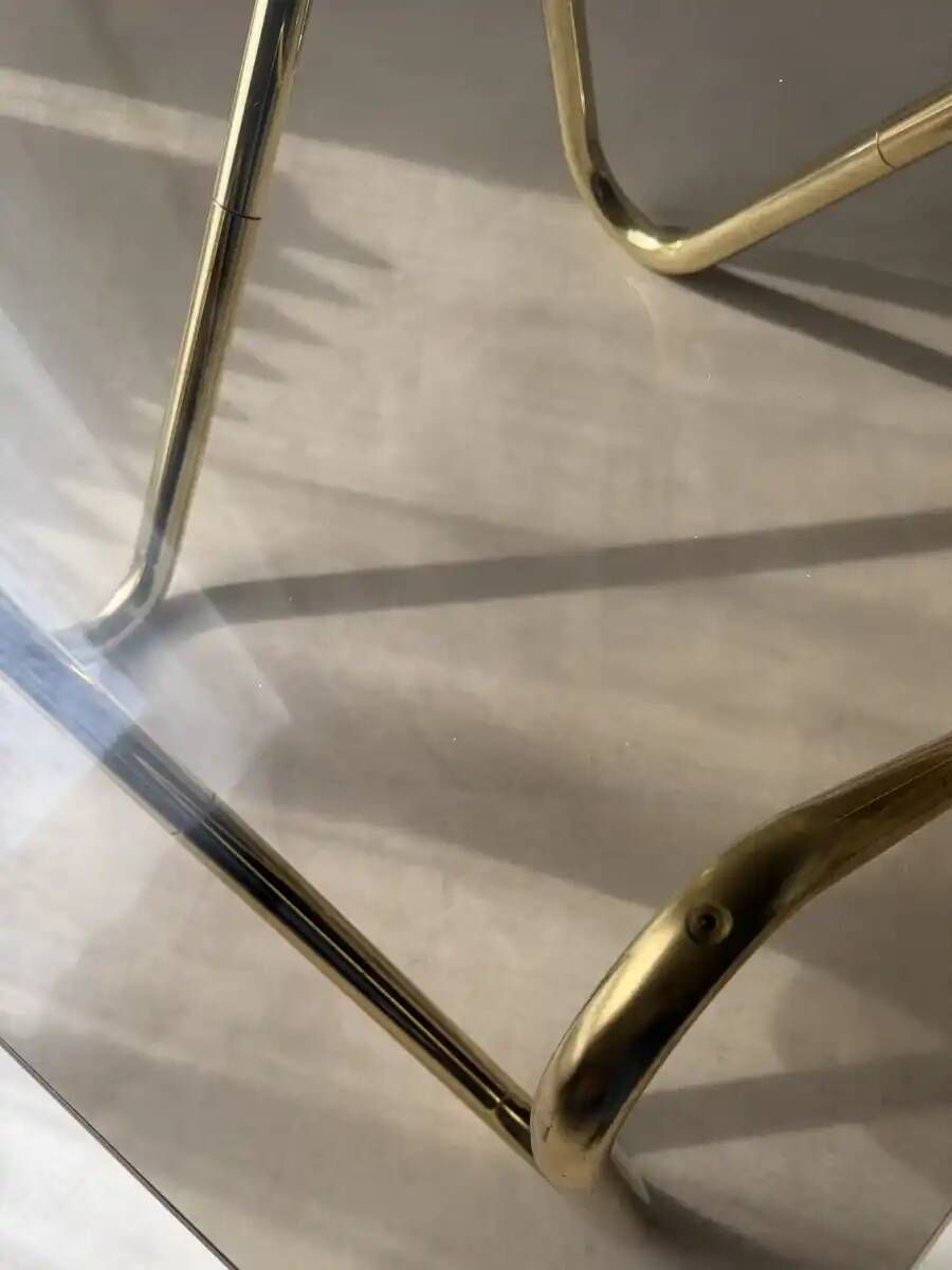 Coffee table with smoked glass and curved metal base
