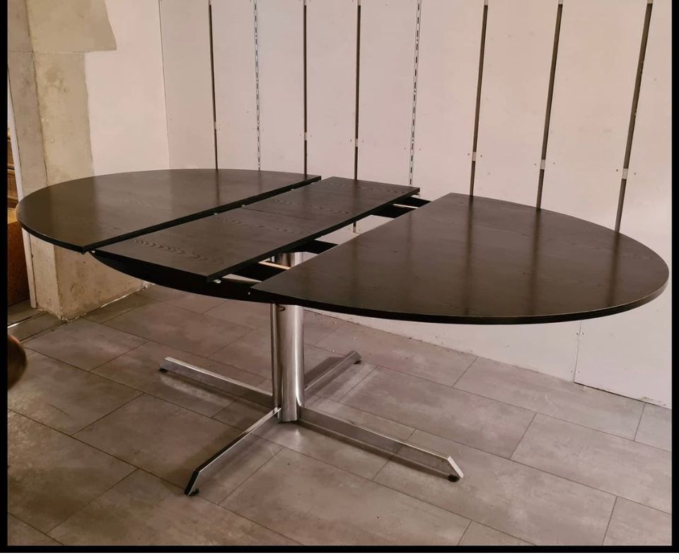 Blackened wooden dining table and chrome foot with integrated butterfly extension