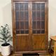 Vintage wooden display cabinet with textured glass.