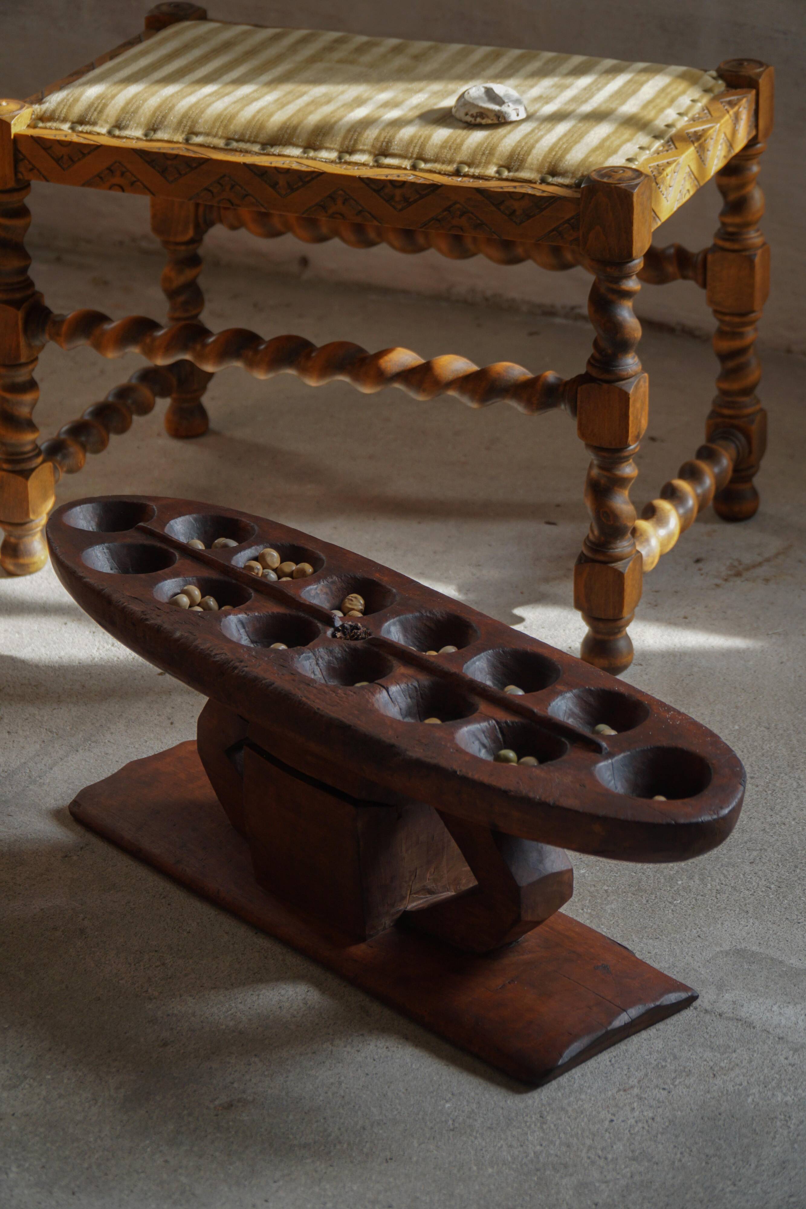 Decorative Mancala game board made of hand-carved wood, Africa, mid-20th century.
