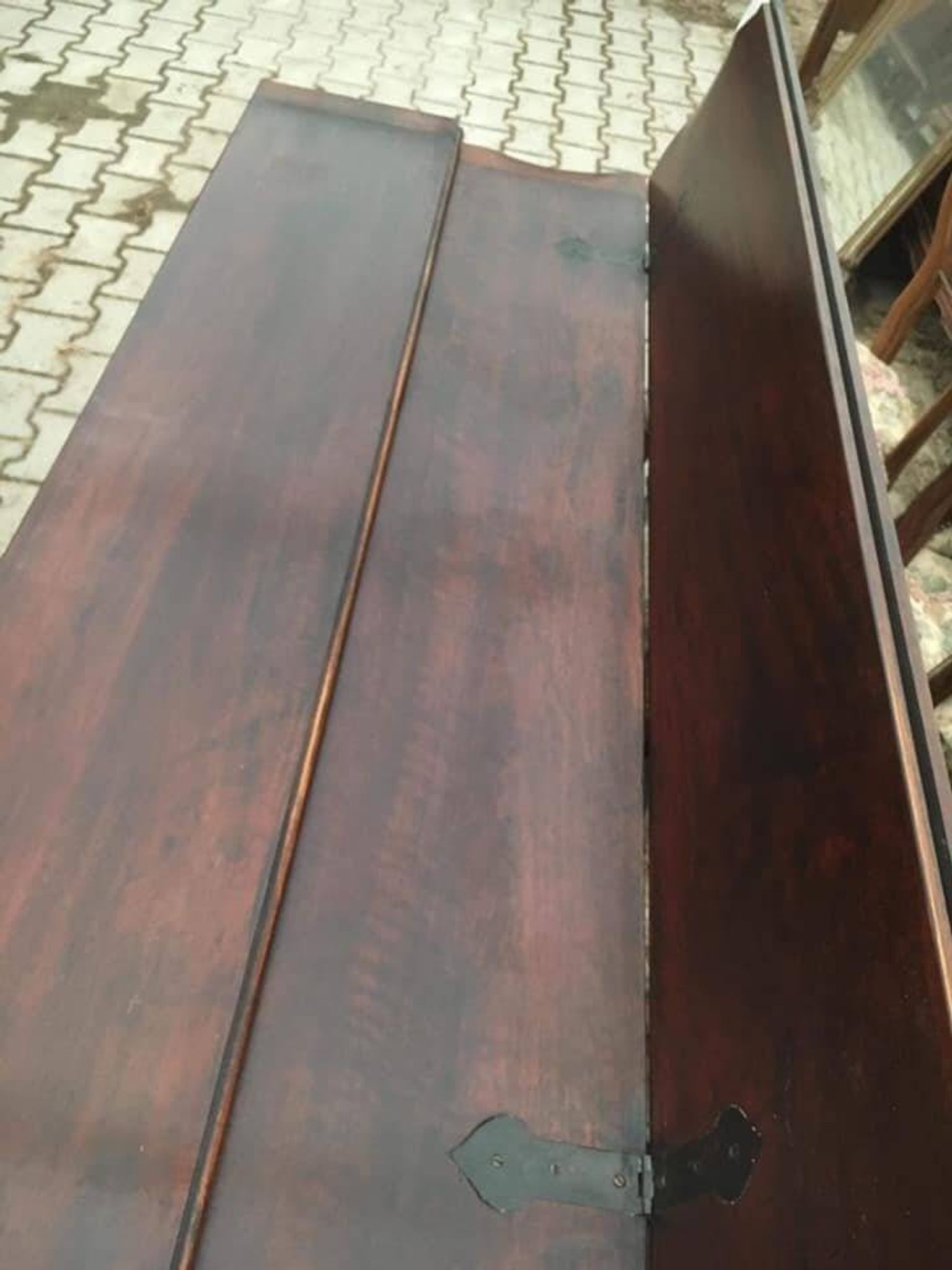 19th-century brown walnut dining table with sculpted trestle legs.