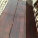 19th-century brown walnut dining table with sculpted trestle legs.