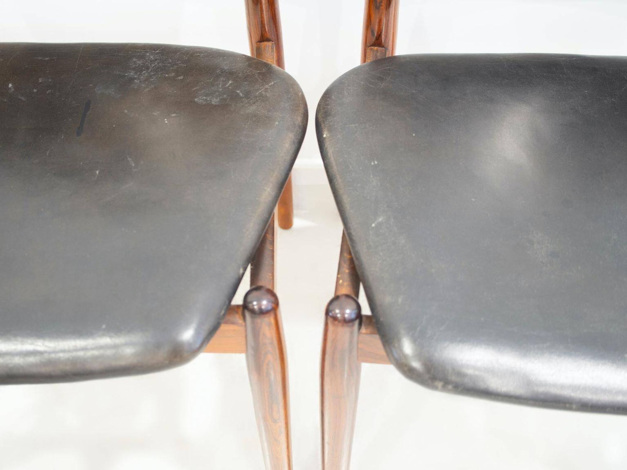 Set of four Arne Vodder chairs in hardwood and black leather.