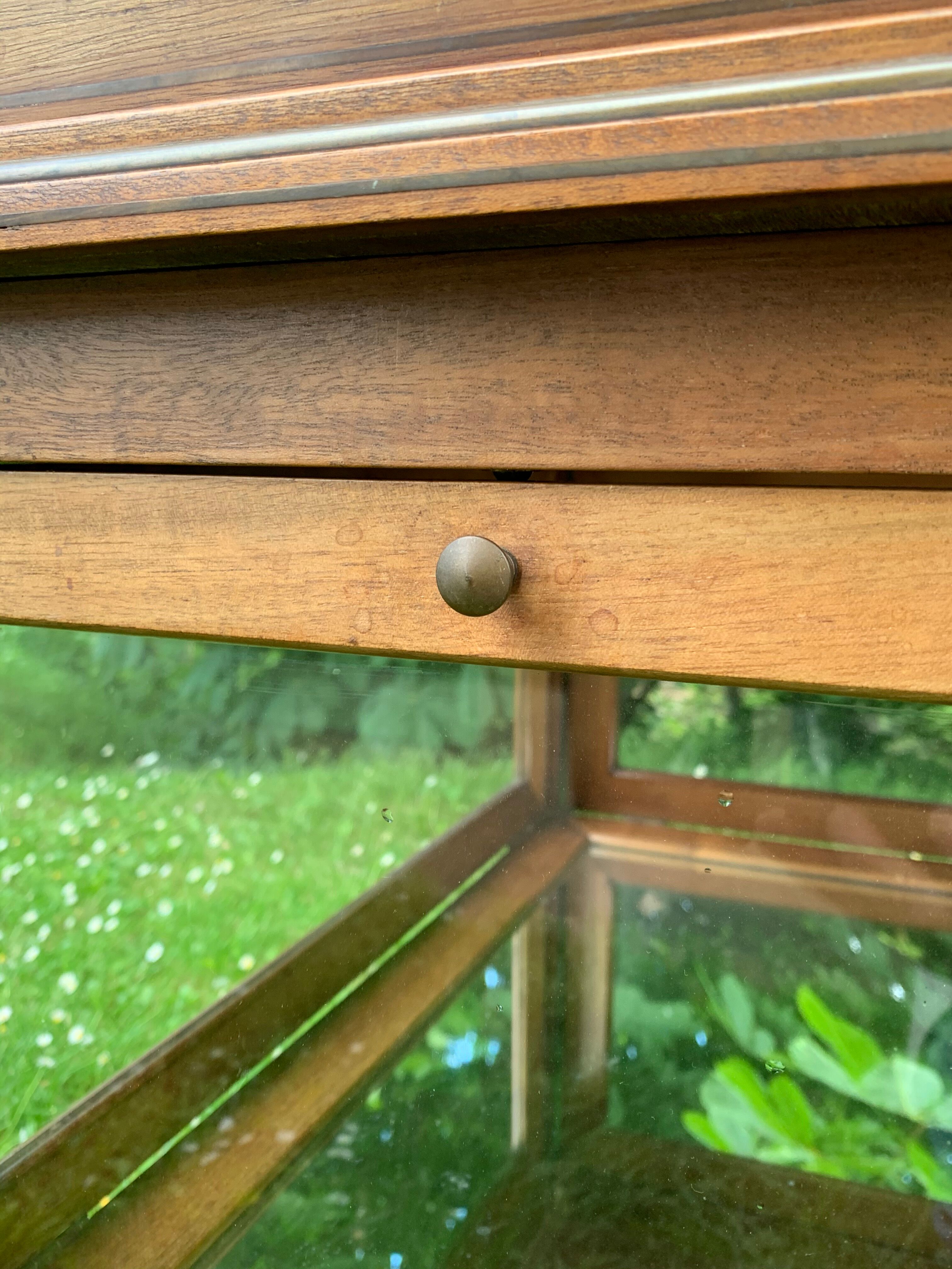 Glass-enclosed old tea table with wooden tray, bronze and brass