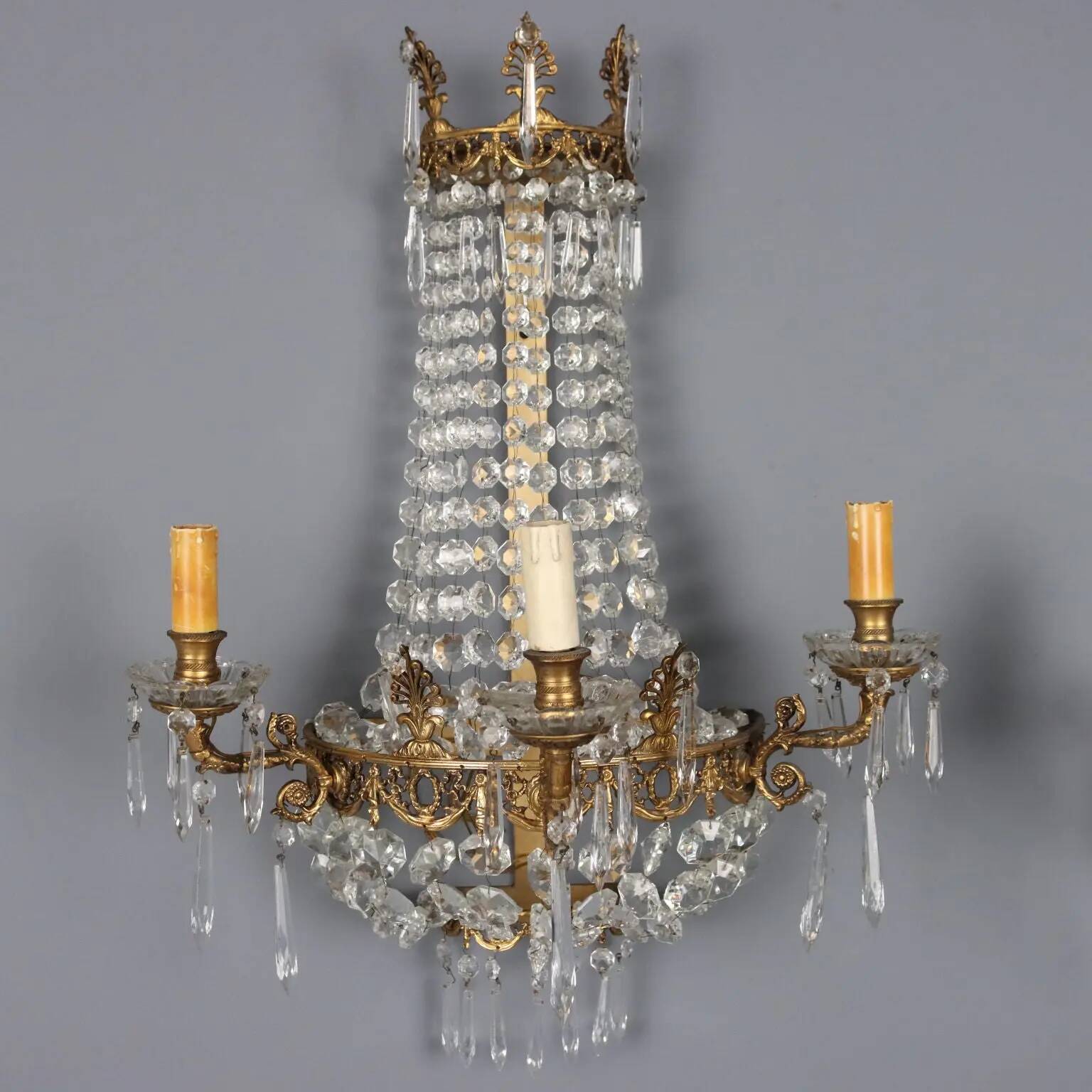 Antique wall sconces in gilded bronze with neoclassical motifs, 20th century.