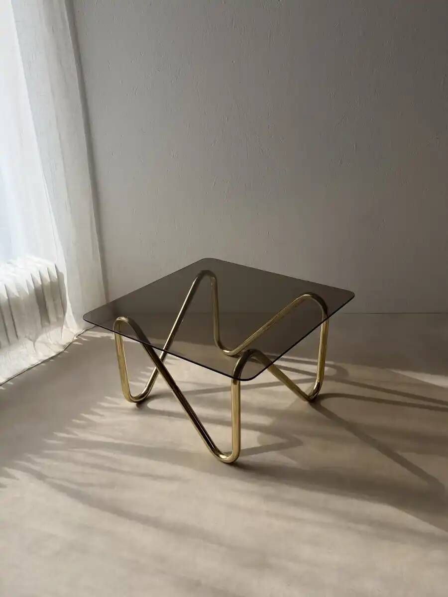 Coffee table with smoked glass and curved metal base