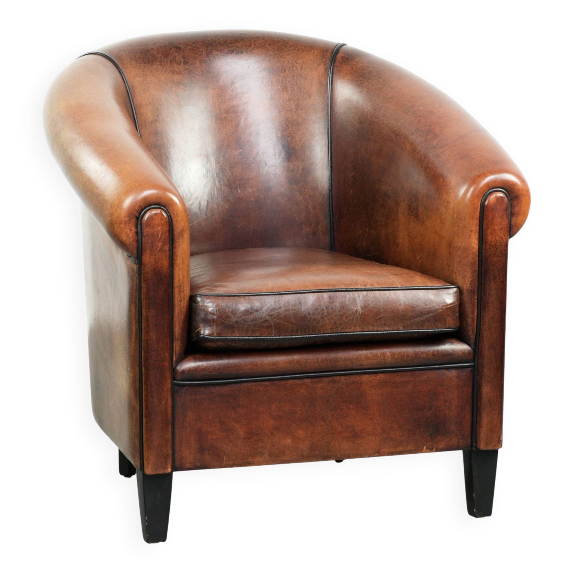 Sheepskin club armchair with deep warm colours and black piping