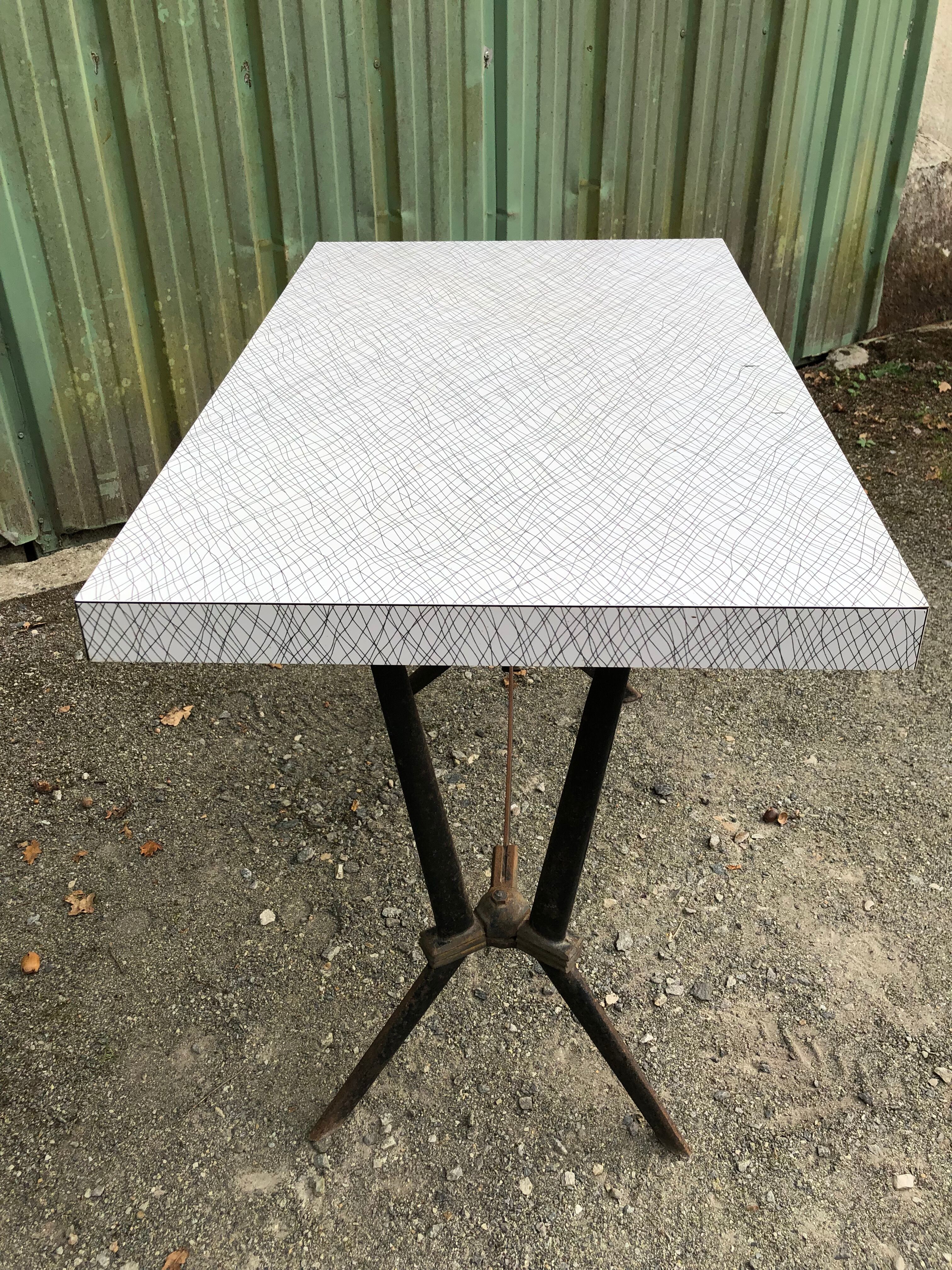 Vintage bistro table with an Art Deco style cast iron base and Formica top.