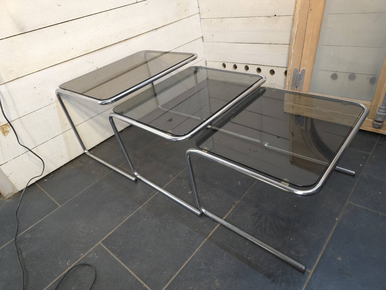 Nesting tables in chromed metal with smoked glass tops from the 1970s